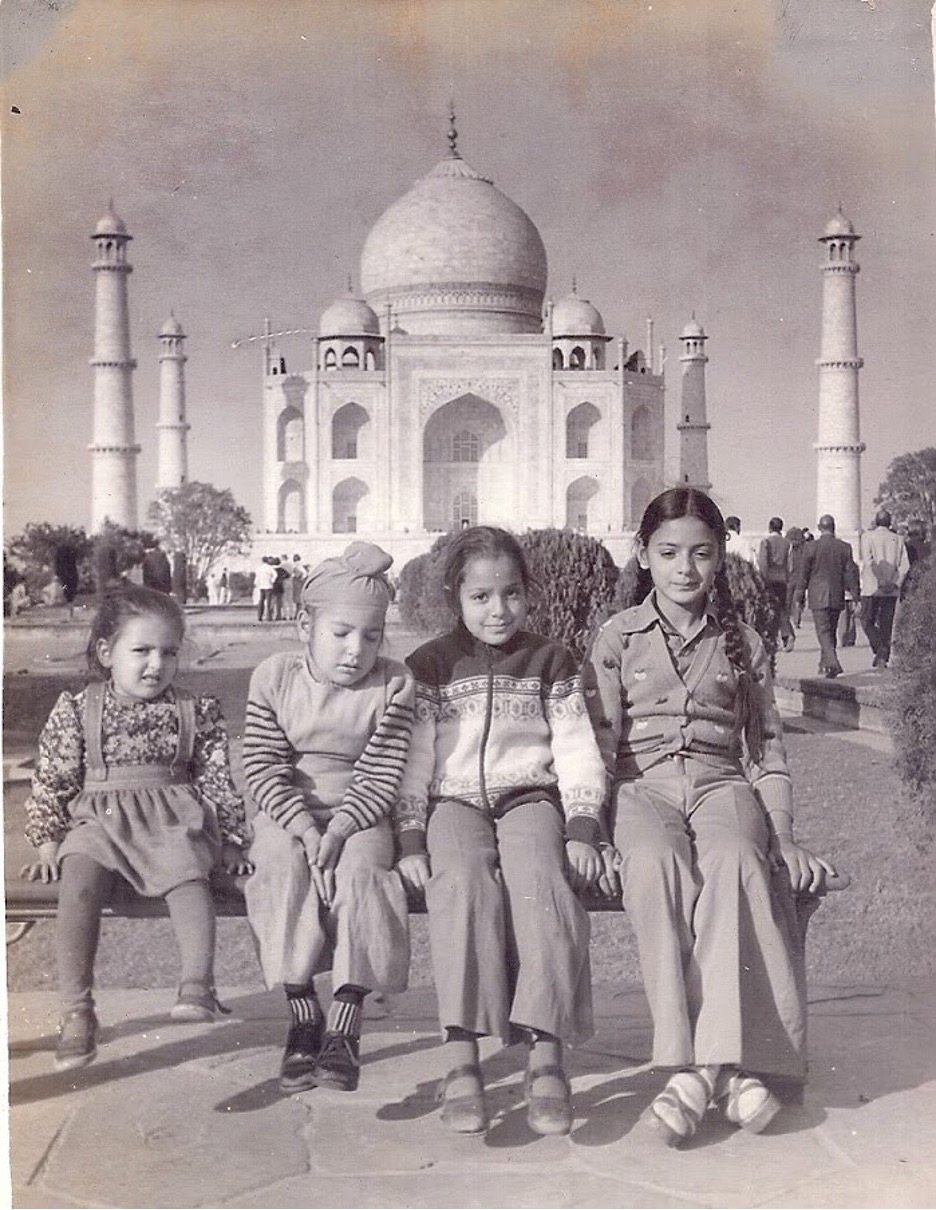 Black and white photo of children sat in front of the Taj Mahal