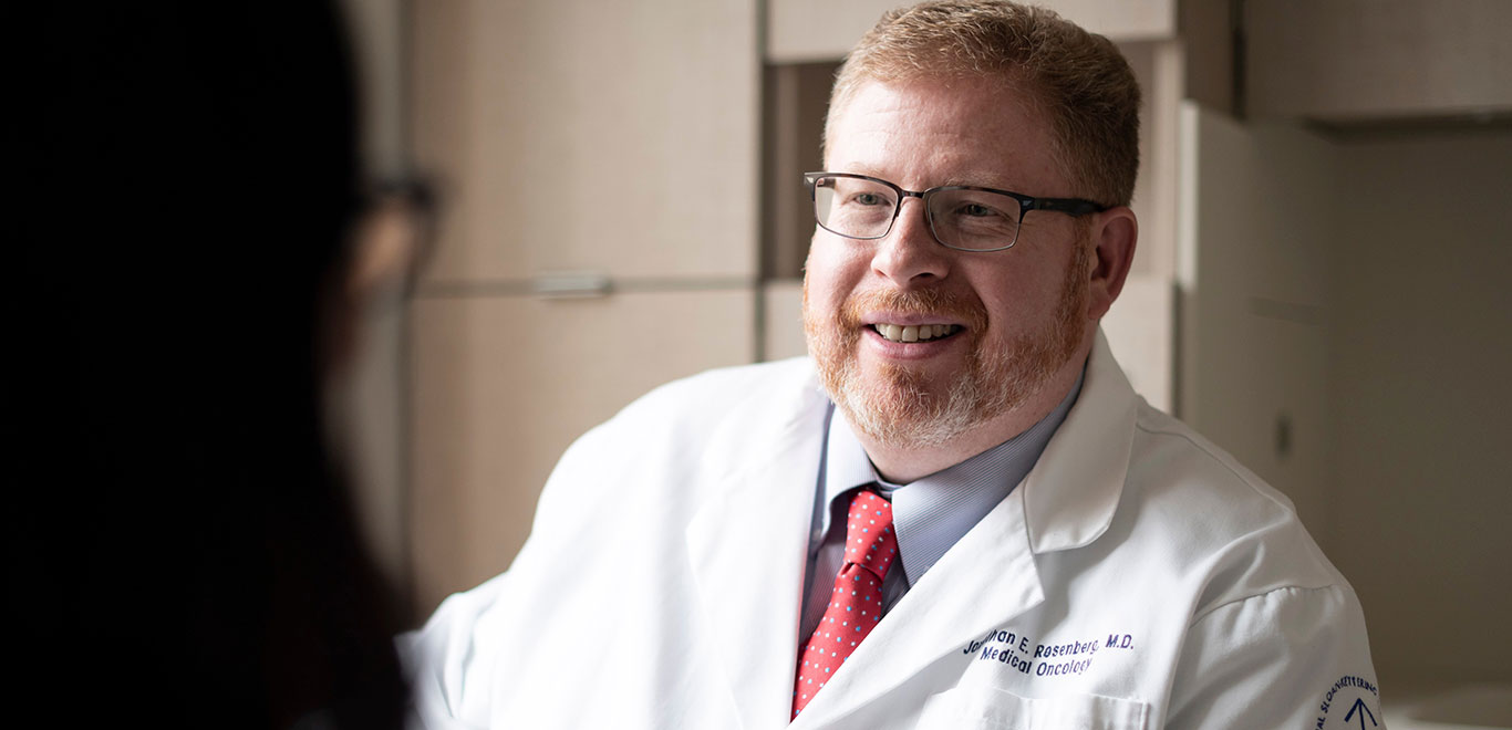 MSK colleague in lab coat talking to another person