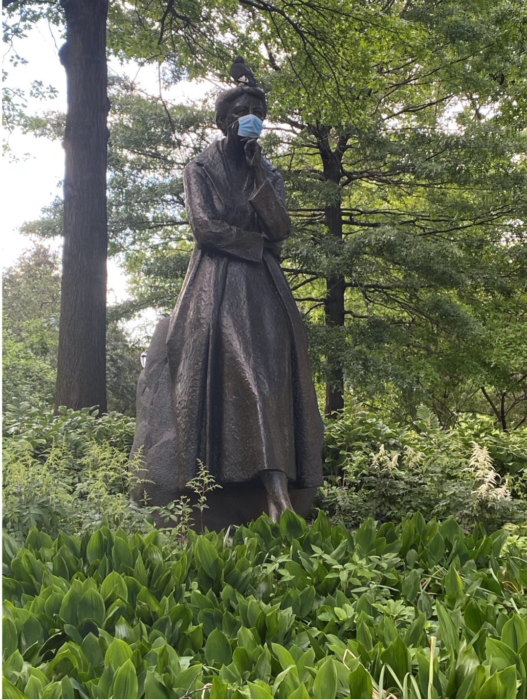 Bronze statue with a mask on it