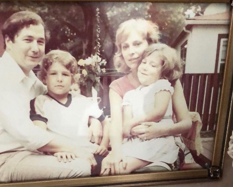 Old family photo with a couple and two kids on a swing