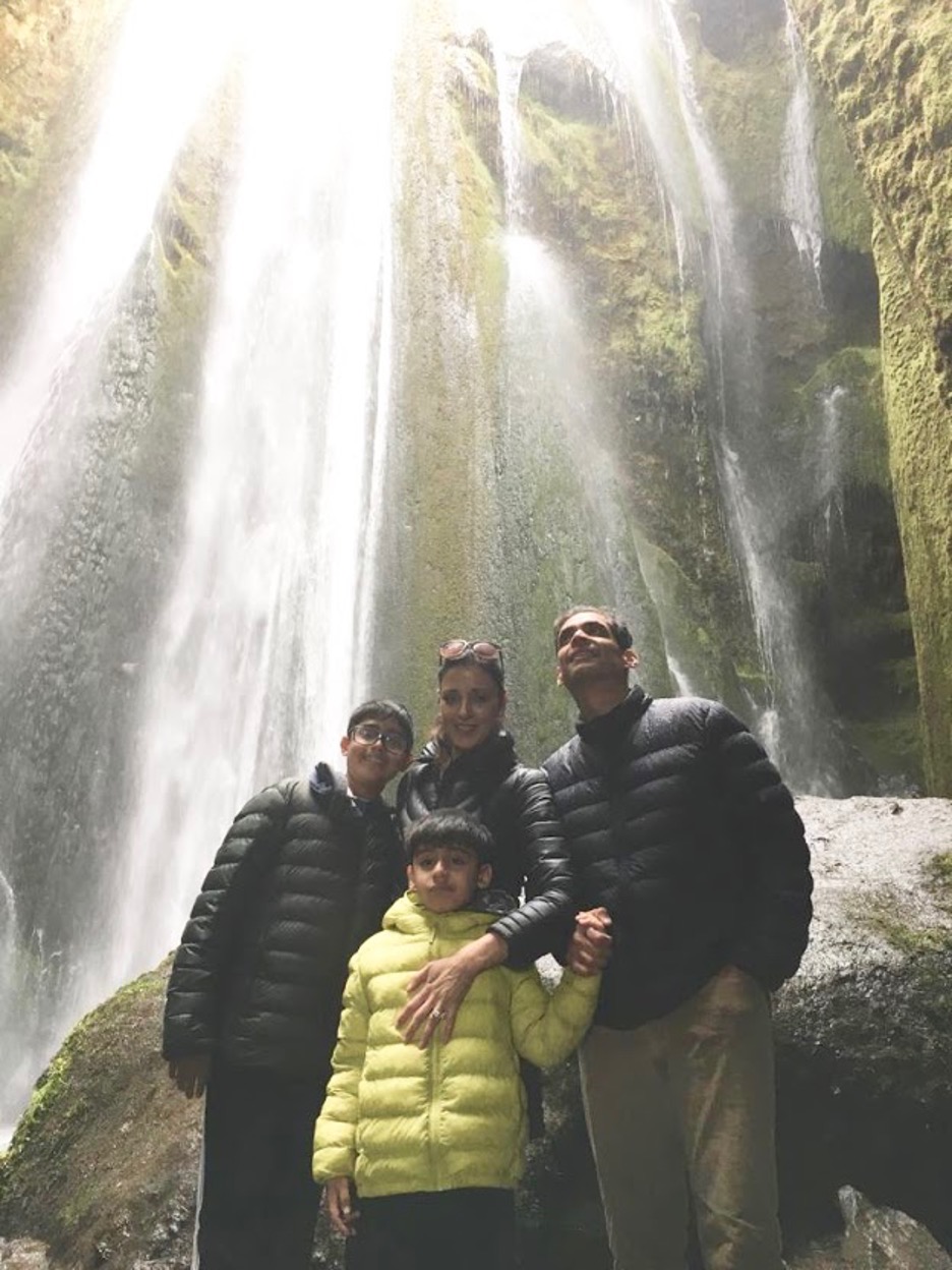 A family stood in front of a waterfall
