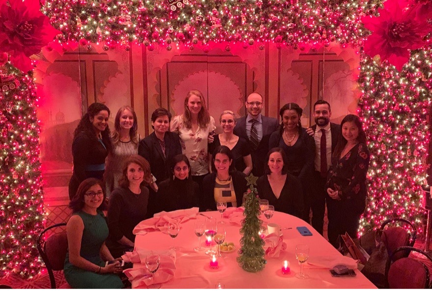 Group of colleagues at a dinner table with floral decorations