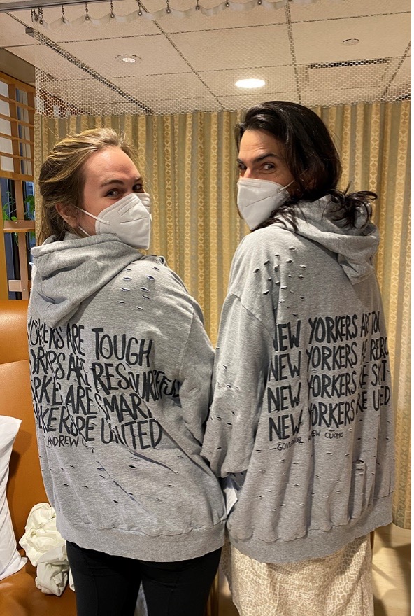 Two colleagues with matching grey hoodies that say New Yorkers are Tough