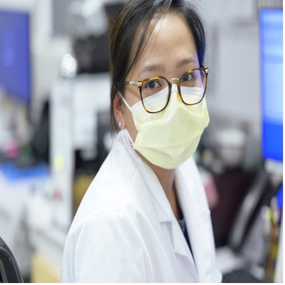 MSK colleague in lab coat sat by computers