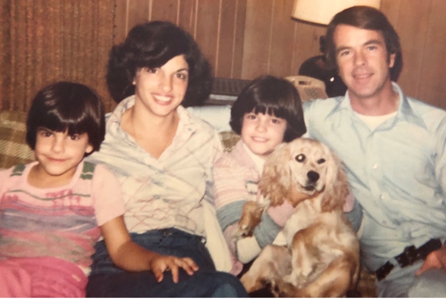 Image of a family sat on a sofa with a dog